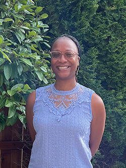 Stephanie Folarin is an African American Woman smiling with braided hair