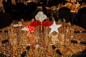 View of decorated table covered in gold and with red and white flowers