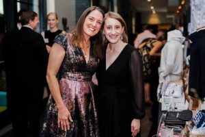 Two women with arms around each other smiling for the camera