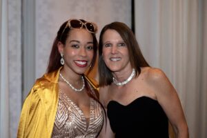 Two women dressed fancy and smiling for the camera