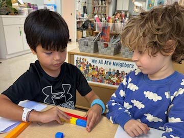 Two boys looking over a math problem on desktop together