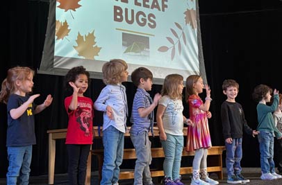 CHS Students on stage with presentation about Leaf Bugs on the screen behind them